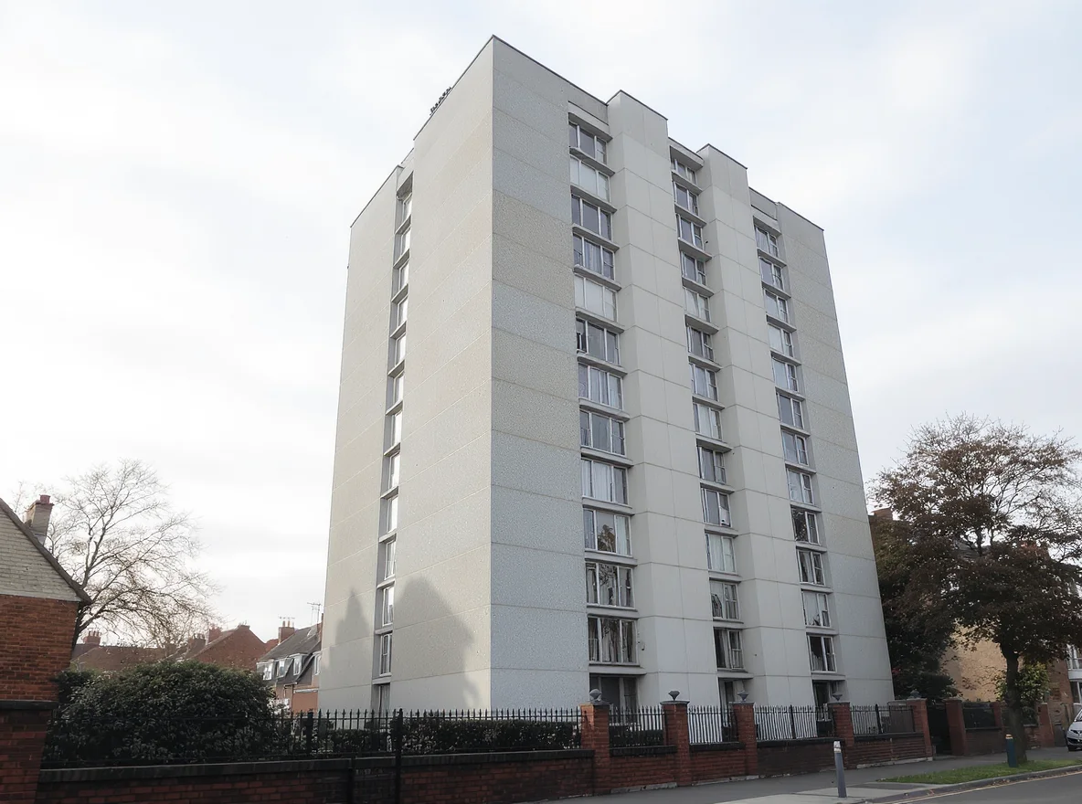 A typical UK residential high-rise block with pale cream cladding panels visible on its facade