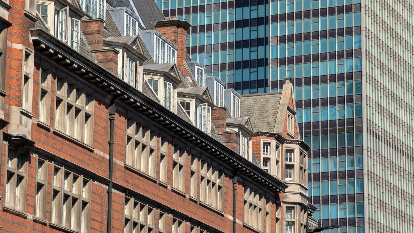 Red-brick London mansion block flats against modern glass office towers