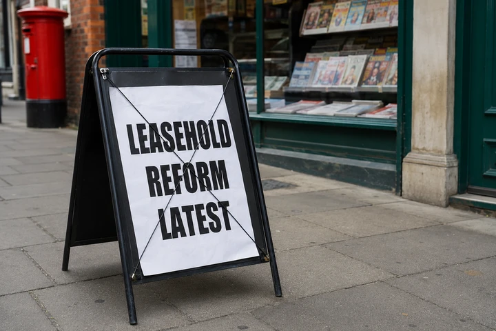 An A-frame pavement board outside a London newsagents with a news placard reading Leasehold Reform Latest