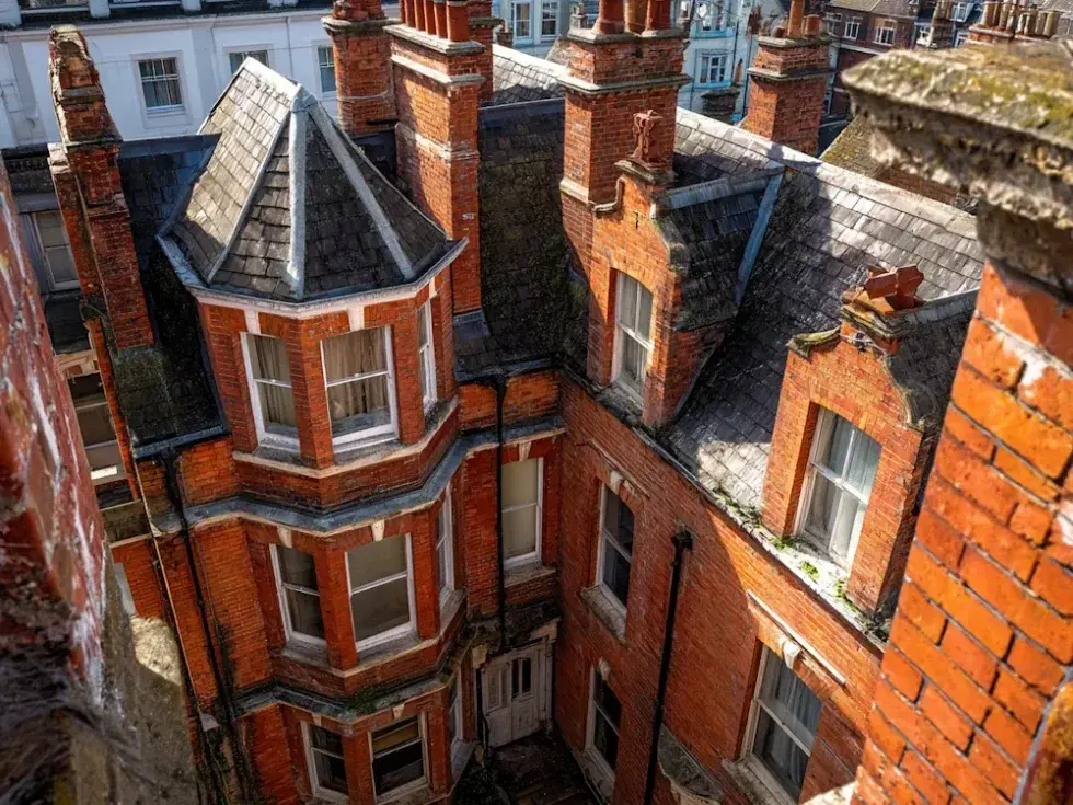 Roof tops and chimney of red brick Victorian block of flats