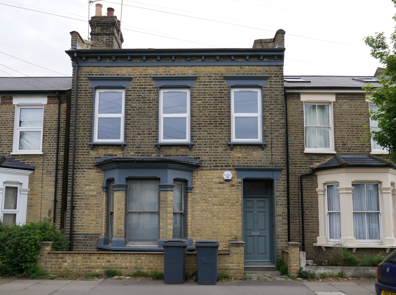 London Victorian terraced house converted into two flats, with a shared front door and two wheelie bins outside